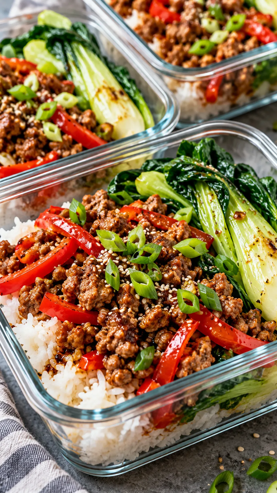 Close up shot of cooked Ginger Tamari Turkey Bowls with jasmine rice, tender stir-fried red peppers, steamed bok choy, and a sprinkle of green onion tops, served in clear glass meal prep dishes